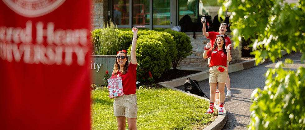 Three college orientation leaders cheering