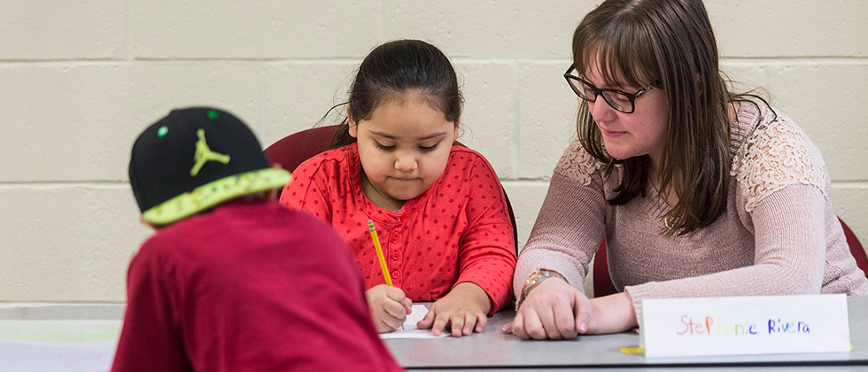 Teacher watching student write