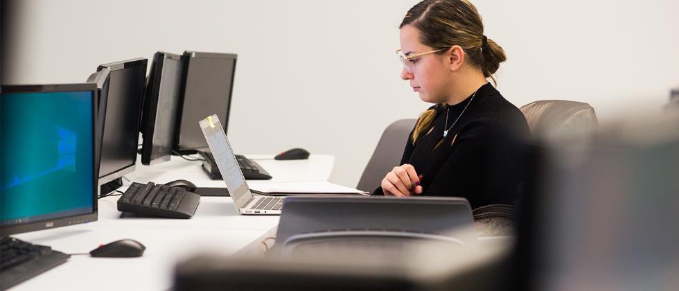 Woman using laptop in computer lab