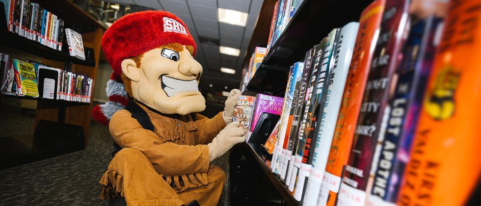 Big Red looking at books in library