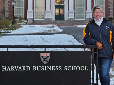 Patricia Betron standing with Harvard Business School sign