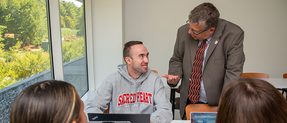Professor talking to student in classroom