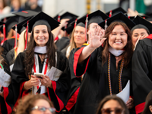 Graduates waving at Commencement