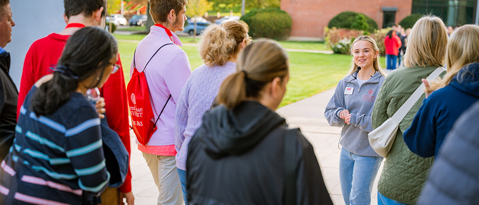 Tour guide leading group around campus