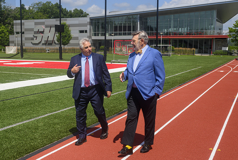 Vincent Ciambriello and John Petillo walking and talking on the track at Sacred Heart University