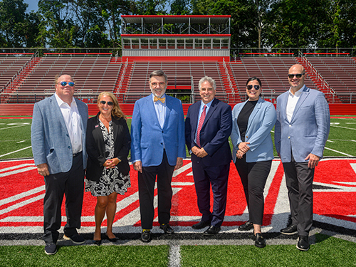 Six people standing on an athletic field