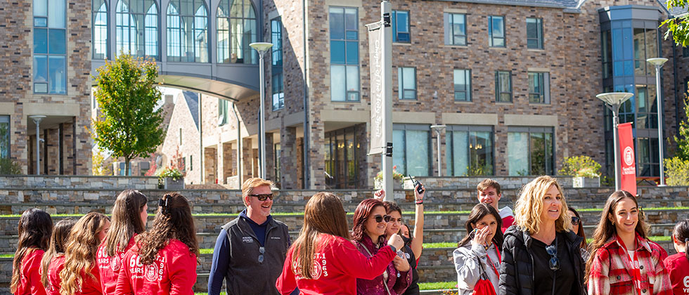 people listening to the leader of a college campus tour