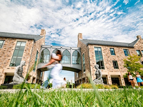 People walking in front of two residence halls