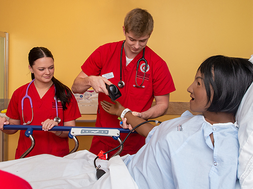 Nursing students practicing on a manikin