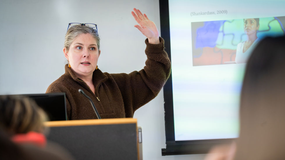 Professor raising her hand in front of the class