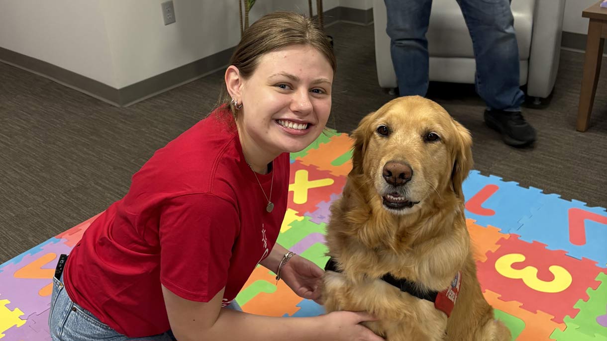 Student researcher with golden retriever