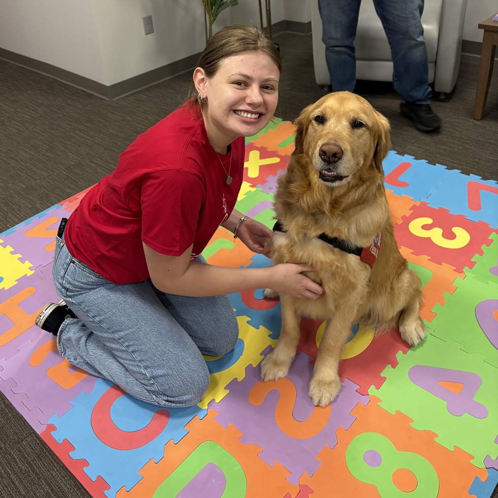 Student researcher with golden retriever
