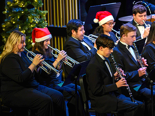 Band members performing in Santa hats