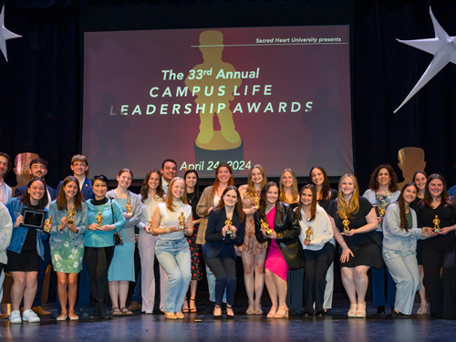 Students on stage with their awards