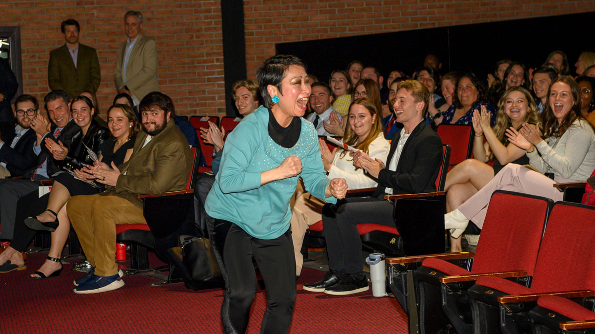 Faculty member celebrating win in front of crowd