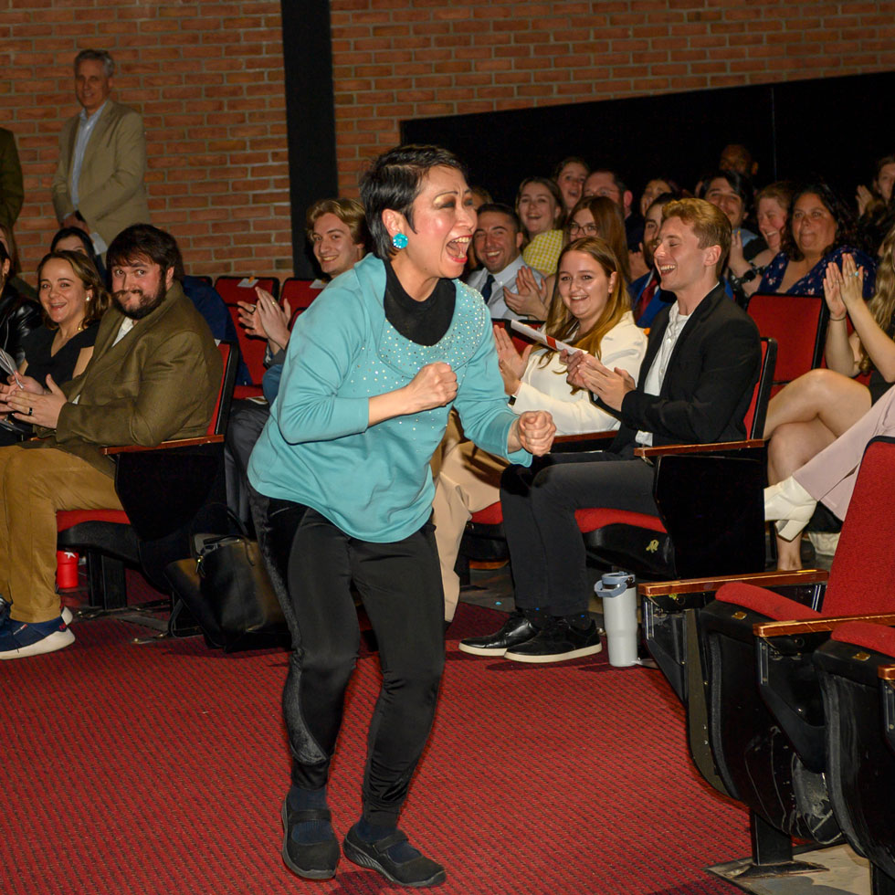 Faculty member celebrating win in front of crowd