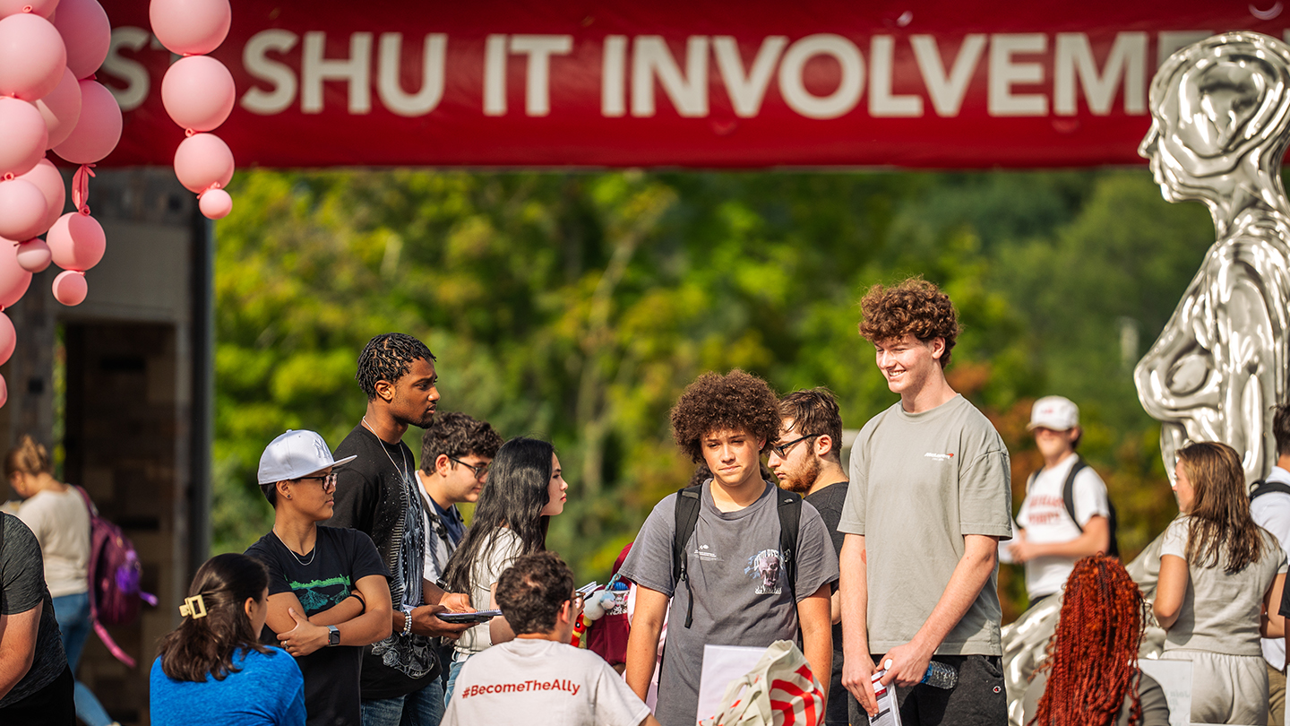 Students visiting an information table at a college involvement fair