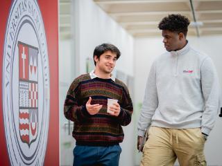 Two people walking and talking over coffee