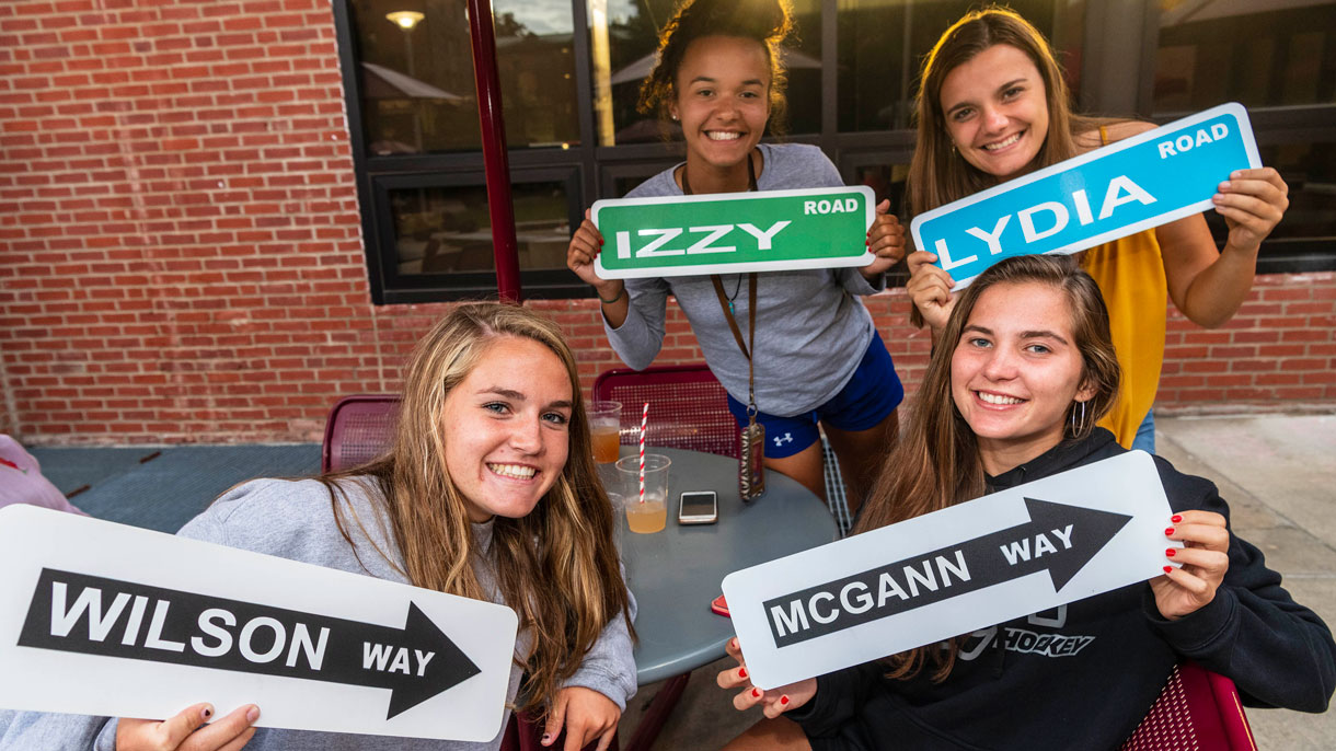 Students holding up personalized street signs