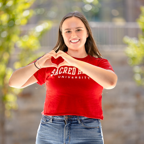 Student making a heart with her hands