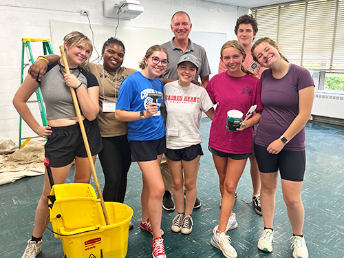 student volunteers gather for a photo at a work site