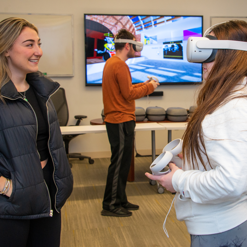 Girl watching another girl use VR