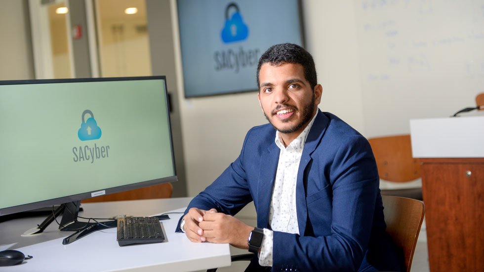 Student smiling sitting in front of computer