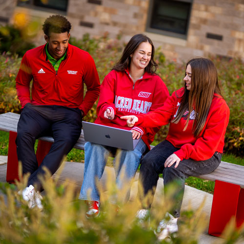 Students sitting on bench outside