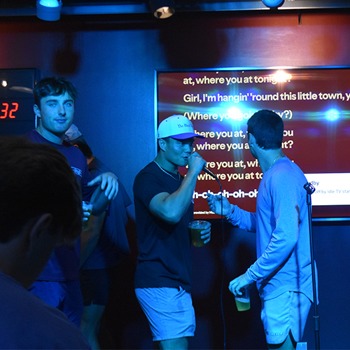 three people doing karaoke at a pub