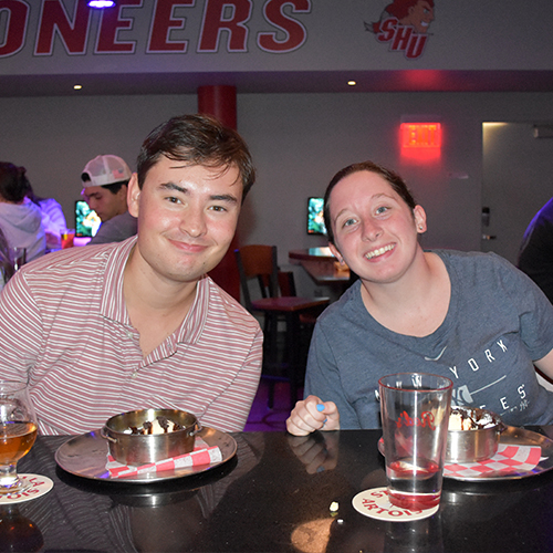 two people sitting at a bar and smiling