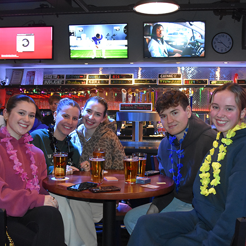 group of smiling people at a pub