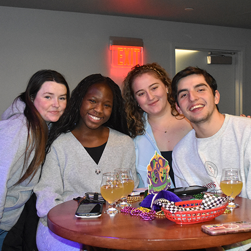four smiling friends posing for a photo
