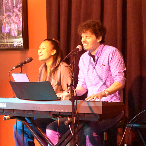 two musicians singing and playing a keyboard