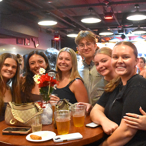 six friends sitting together at a pub table