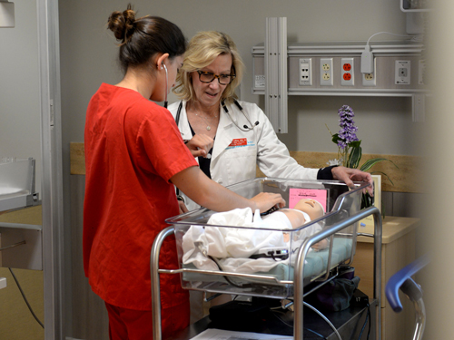 Professor with nursing student in lab