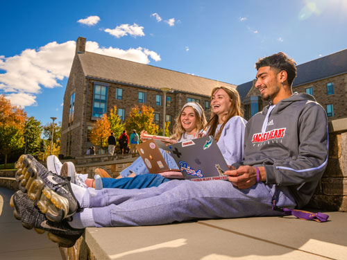 Students sitting outside on their laptops
