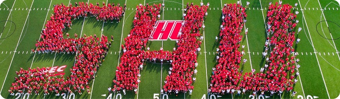 Students standing on the football field spelling out SHU