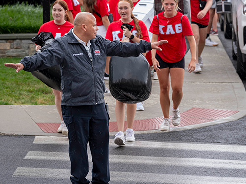 A public safety officer stopping cars for foot traffic in a crosswalk