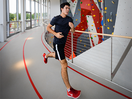 a college student running on an indoor track