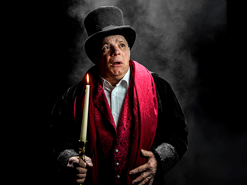 Man wearing a top hat and a lit candle