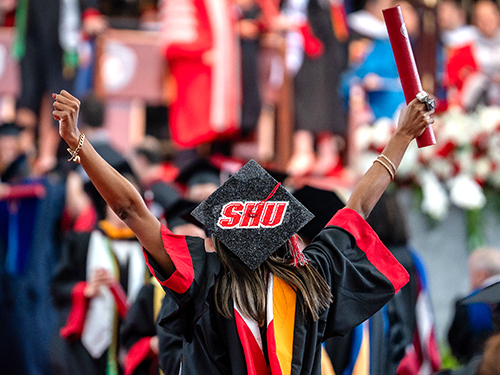A graduate celebrating at commencement
