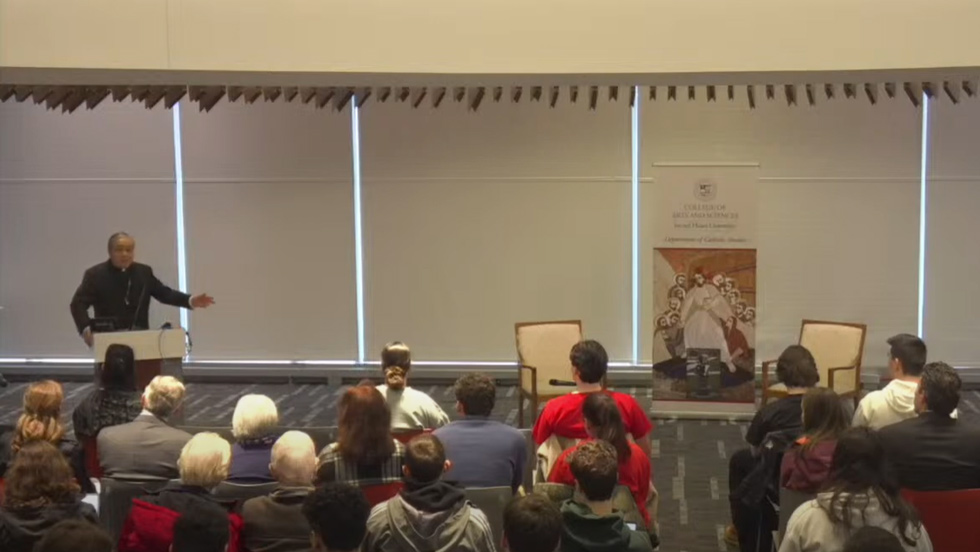 Man speaking to audience at podium