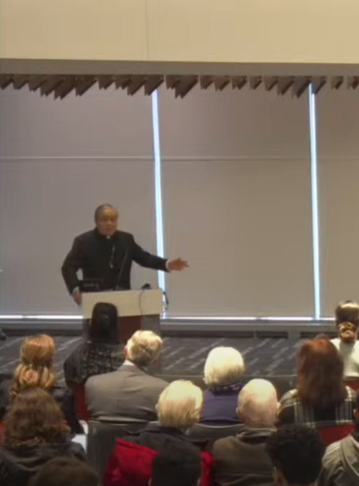 Person speaking to audience at podium